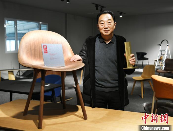 圖為產(chǎn)業(yè)園內(nèi)的一家公司負(fù)責(zé)人展示獲得德國IF設(shè)計(jì)金獎(jiǎng)的椅子?！∷蚊魸?攝